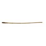 A walking cane that is yellowish in colour and is made of bamboo with a slight curve in the centre. 