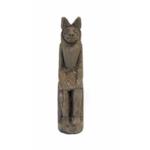 The front of a seated Anubis figurine. It has large ears, eyes, a nose, and mouth that is smiling. 