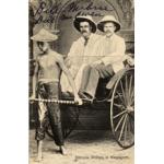 William McRae and William McEwen being pulled in a rickshaw by a local boy. They are wearing white suits and pith helmets.