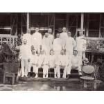 Group photograph of foreign drillers in Borneo all wearing white suits. They are posed in front of a building on a set of steps. 