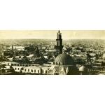 Une photo de la ville du Caire prise d'un toit. Il y a un bâtiment en dôme au premier plan et une tour juste derrière. 