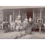 Group of oil drillers in Burma, outside their quarters. Joe Scarborough is standing at the top and Bill Hutchinson is standing with a horse.