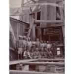 Harry Phillips and his crew posed in front of an oil rig. 