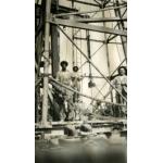 An International Driller and two local workers standing underneath an oil rig.