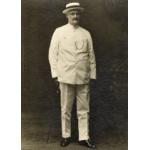 William McRae standing in a white suit and boat hat.