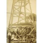 A Canadian Pole-Tool Drilling Rig, which is  wooden oil rig with  four legs and crossbeams moving up its height.