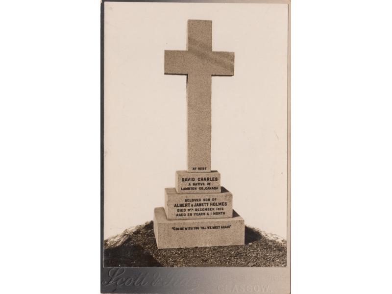 Cemetery marker of Charles Holmes shaped like a cross resting on a three-stepped base