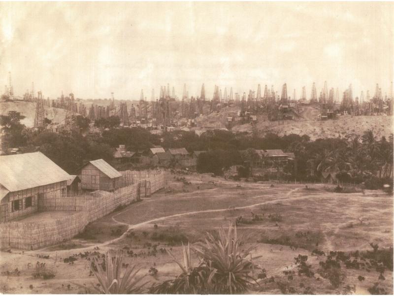 Yenangyoung Oil Field. The background is full of hundreds of oil derricks and the foreground shows houses.