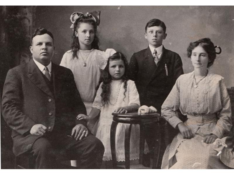 Un portrait de famille avec Fred Webb assis à l'extrême gauche, son épouse à droite et ses trois enfants au centre.