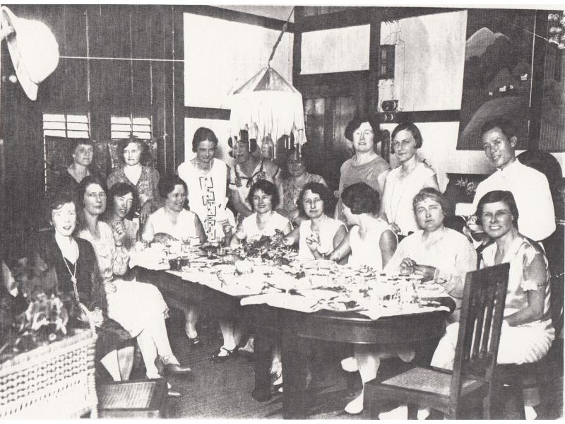 Group of women seated around a table in either a home or restaurant. 