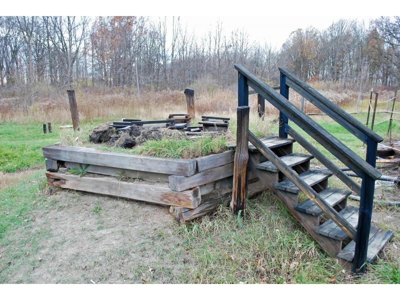 Des marches en bois mènent à un petit réservoir de séparation, encastré dans des caissons en bois.