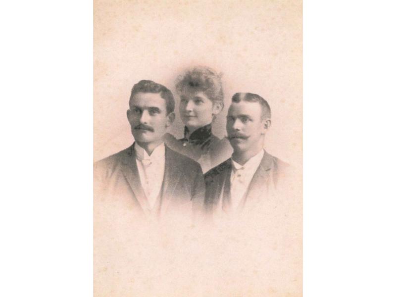 A portrait of Richard VanSickle with his wife and unknown man. She is behind the two men in the middle. They are wearing dark clothes and the image fades out around the edges of their heads and chests.