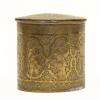 The front of a cylindrical brass pyxis with a design of robed figures and a floral pattern. It has a brass lid that is also patterned.