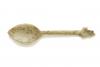 The front of an ivory-carved spoon with a point on the end. It is speckled with brown dots and the top of the handle is shaped like a bud. 