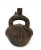 Front side of dark brown stirrup-spout bottle. Decorated with a low-relief, radiating pattern.