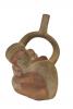 Front side of red and cream coloured stirrup-spout bottle in the shape of a crouched monkey. 