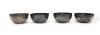 Front side of the set of four silver finger bowls. The two on the left have octagonal sides and the two on the right have smooth sides. They are silver in colour and have detailed patterns inscribed on them.  