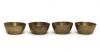 Front view of four brass finger bowls with flared sides and flat bottoms.  