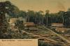 A postcard showing four five buildings and a large holding tank in a clearing. There are two roads. The postcard says: "Groet uit Borneo" and "Oostkust; Petroleumbronnen." 