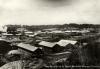 Vista shot of the main camp at an oil field in Colombia. There are three long buildings in the foreground and a group of buildings in the background. 