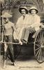 William McRae and William McEwen being pulled in a rickshaw by a local boy. They are wearing white suits and pith helmets.