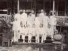 Group photograph of foreign drillers in Borneo all wearing white suits. They are posed in front of a building on a set of steps. 