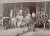 Group of oil drillers in Burma, outside their quarters. Joe Scarborough is standing at the top and Bill Hutchinson is standing with a horse.