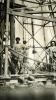 An International Driller and two local workers standing underneath an oil rig.