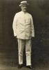 William McRae standing in a white suit and boat hat.